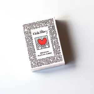 Pasinerkite į menininko Keith Haring energingus kūrinius su šia aukščiausios kokybės kortų kalade.